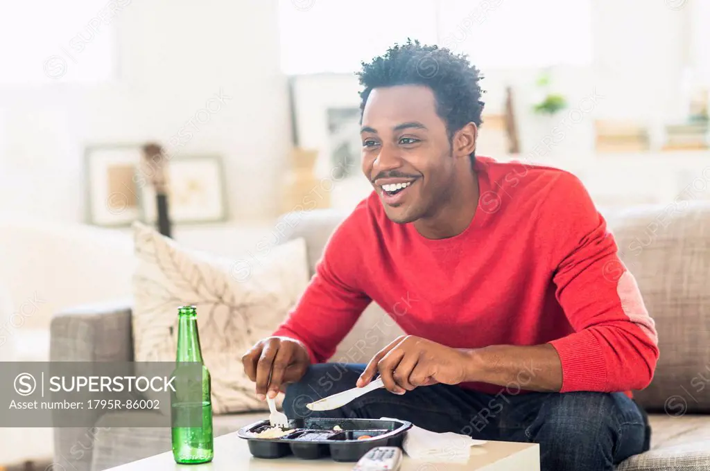 Man eating dinner and watching television