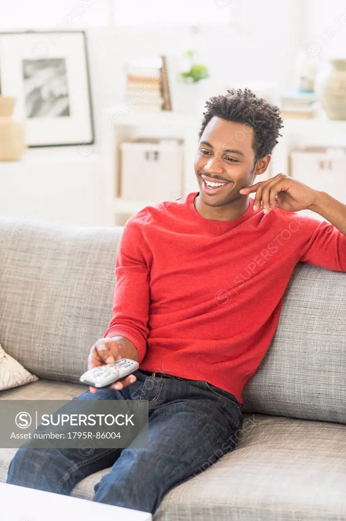 Man sitting on sofa and watching television