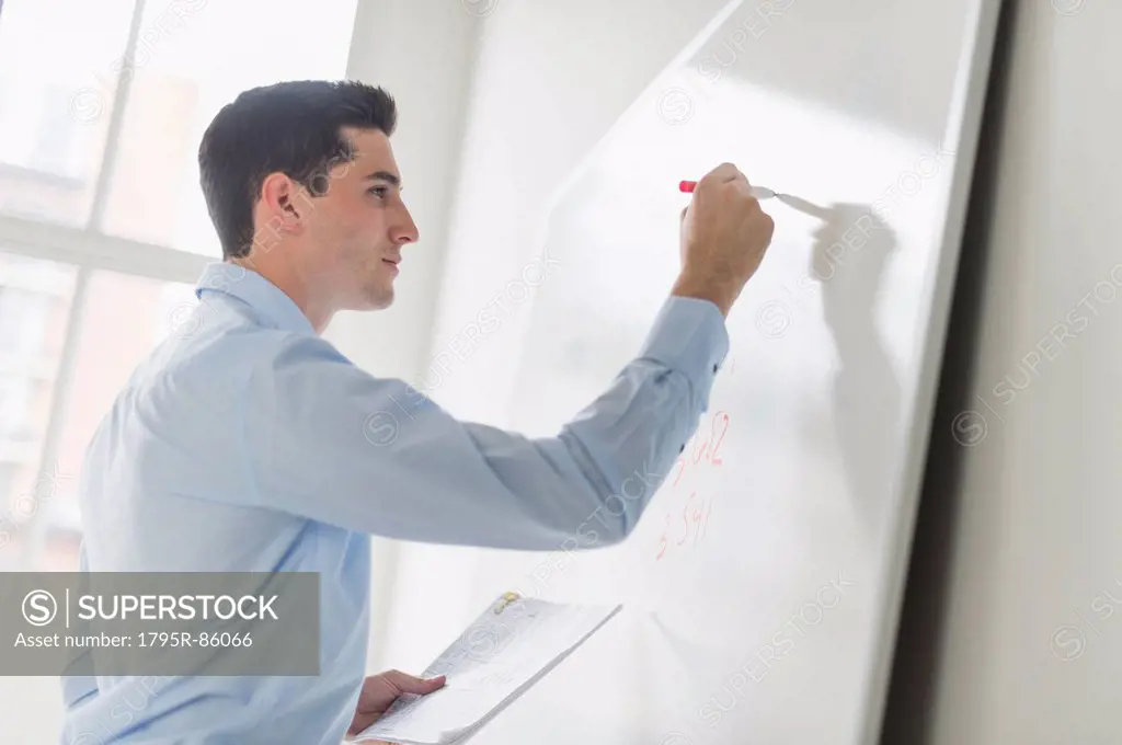 Businessman writing on whiteboard