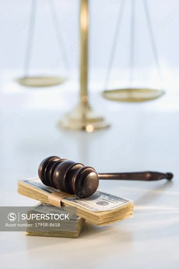 Gavel on stack of money with scales in background