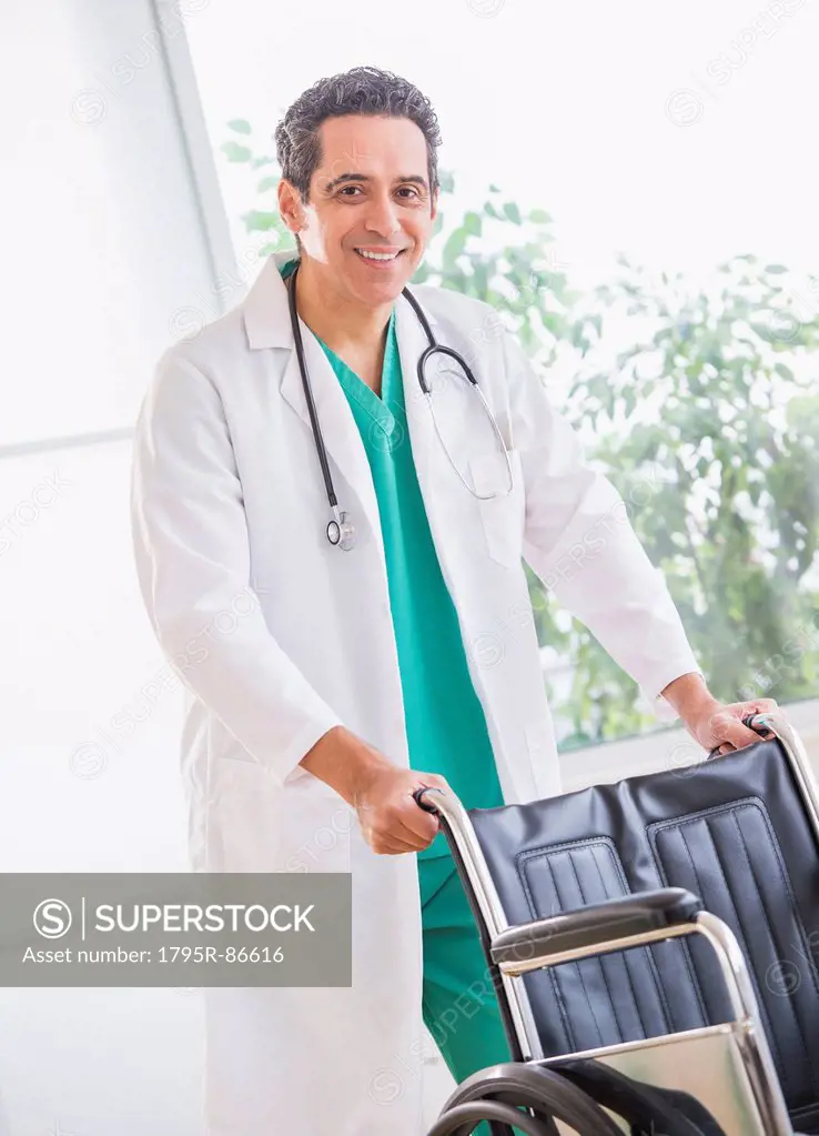 Portrait of doctor standing by wheelchair