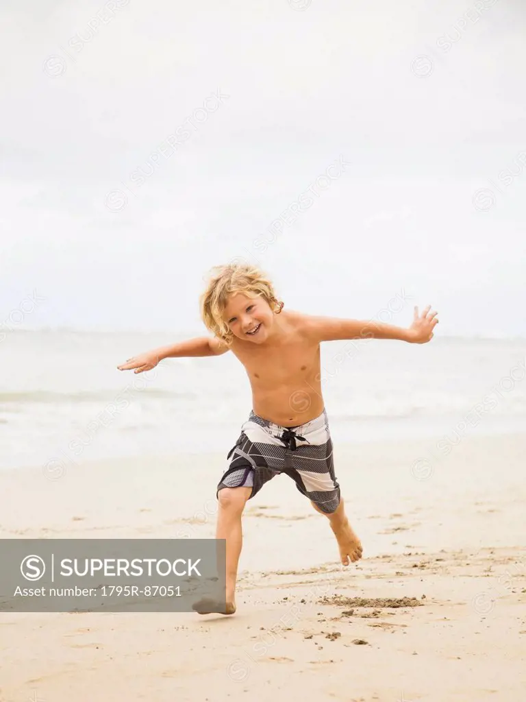 Boy (6-7) playing on beach