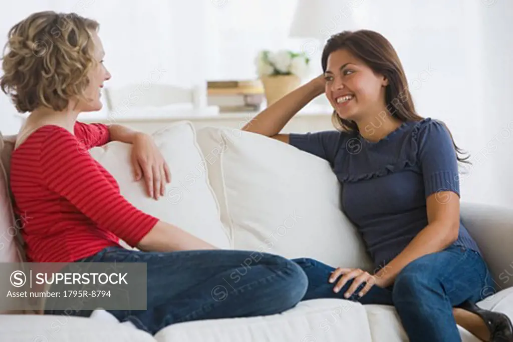 Multi-ethnic woman talking on sofa