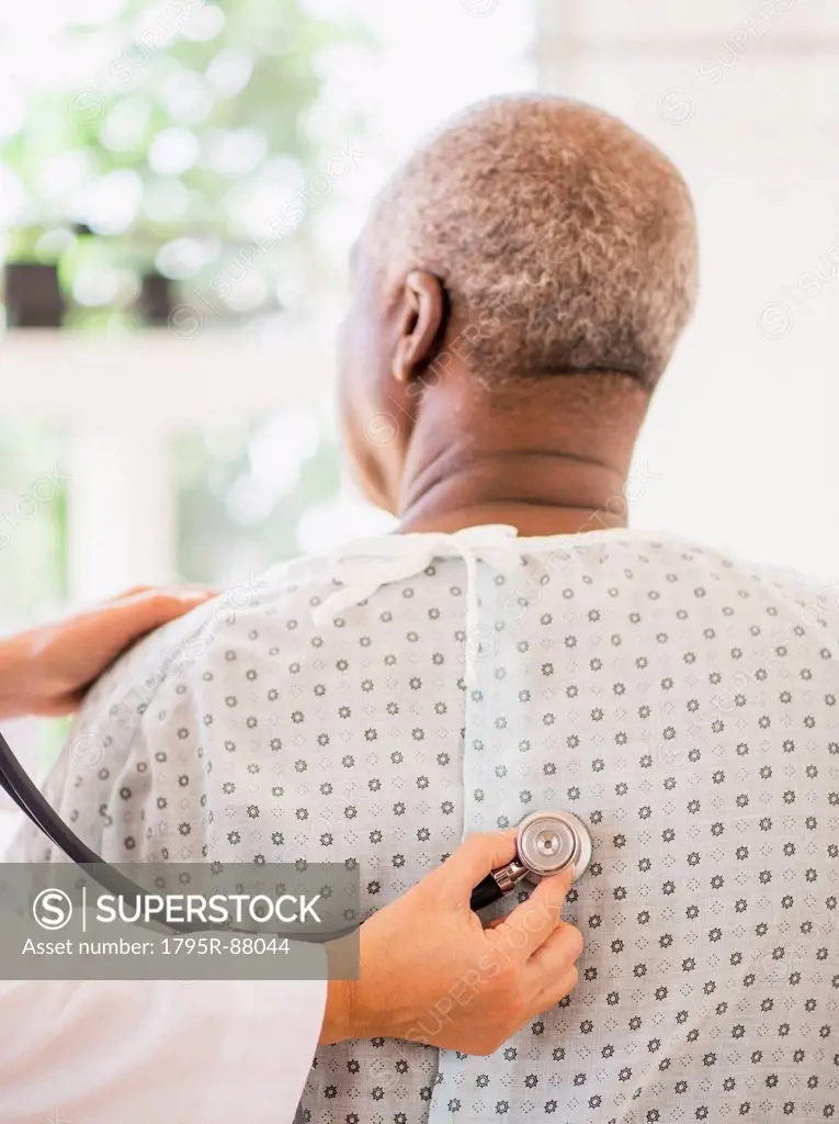 Doctor using stethoscope on patient