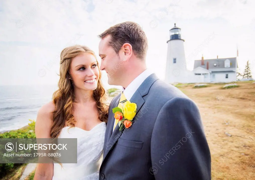 Portrait of married couple, lighthouse in background