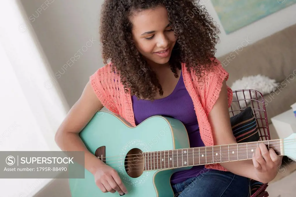 Girl (12-13) playing guitar