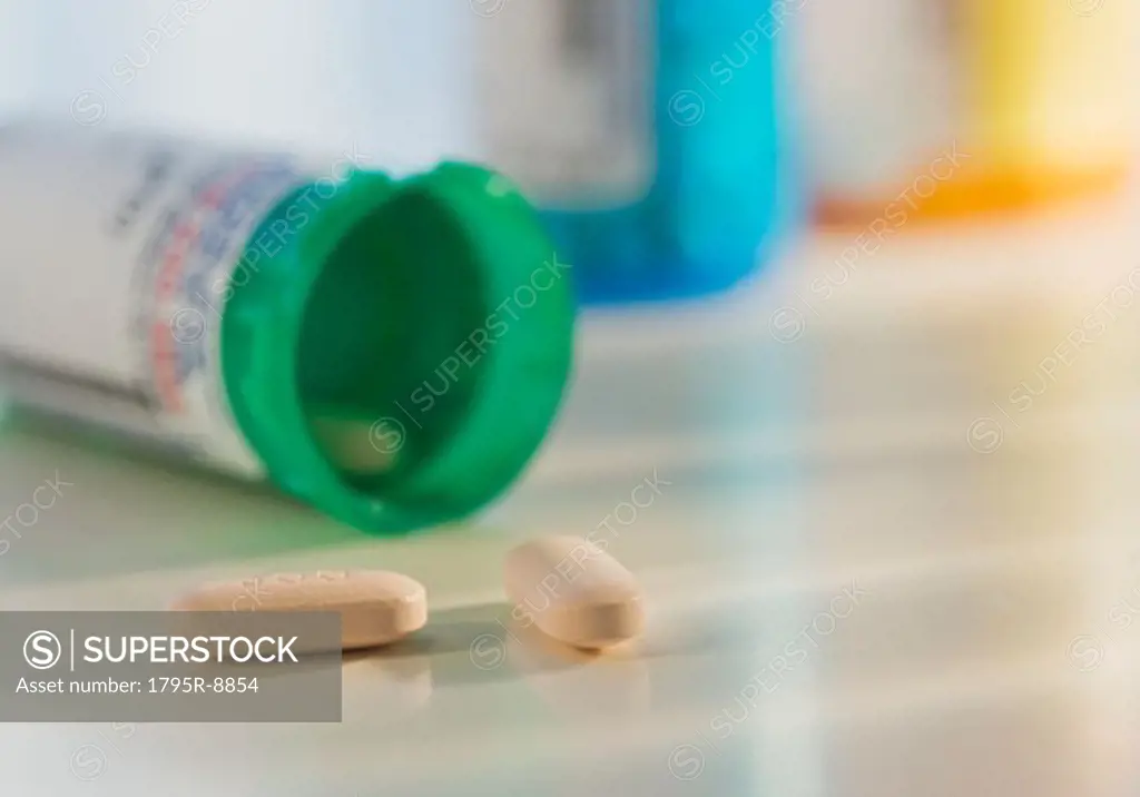 Close-up of pills spilling out of bottle