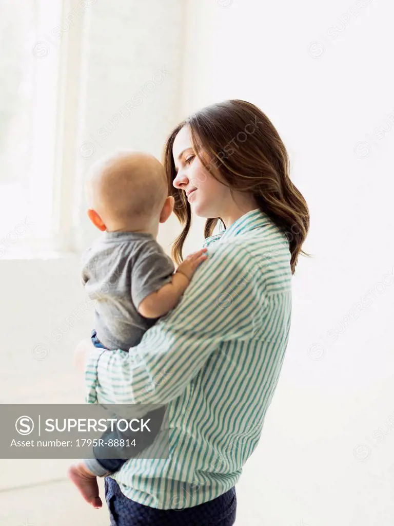 Mother holding baby boy (6-11 months) indoors