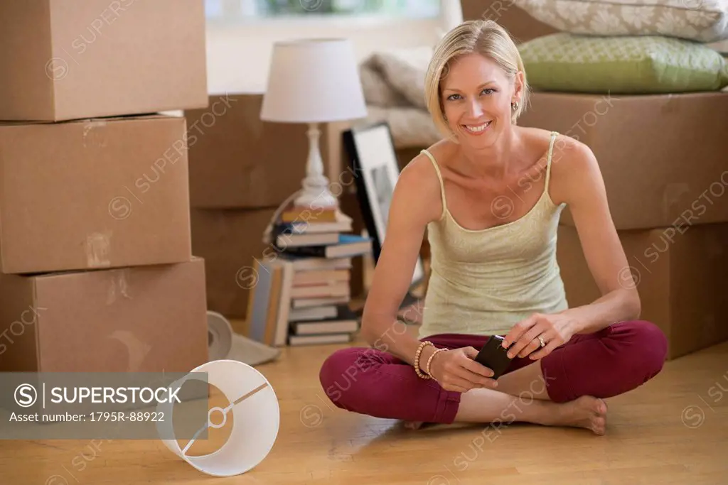 Portrait of woman sitting on floor of new home