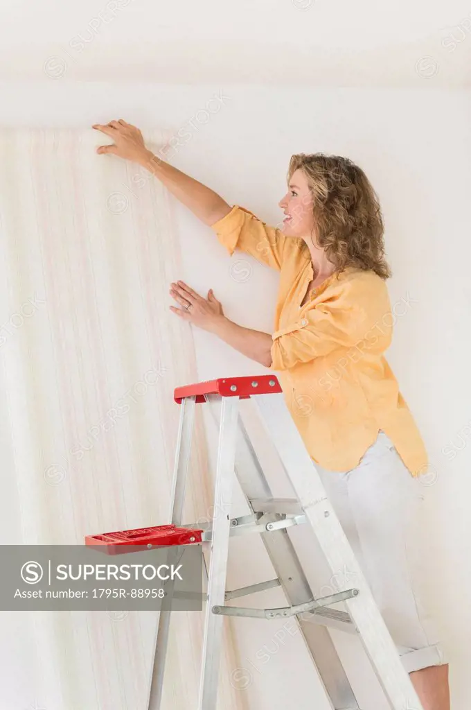 Woman trying out new wallpaper at home
