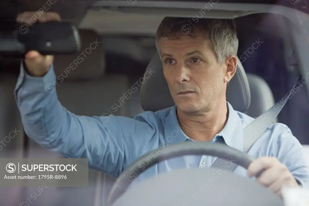 Man adjusting car rear view mirror