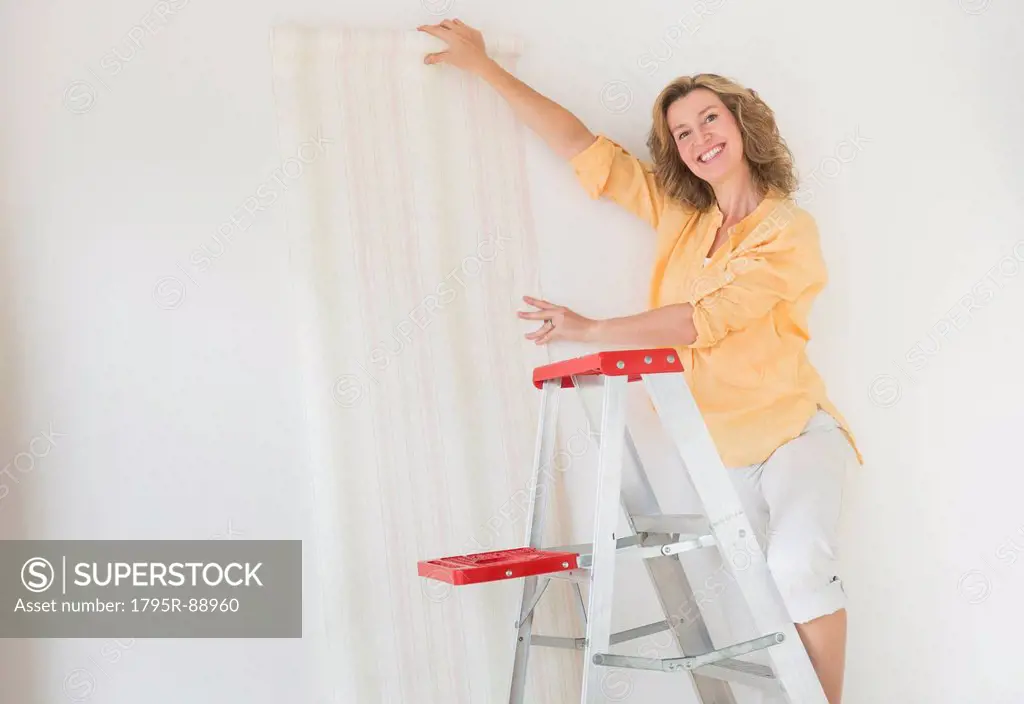 Woman trying out new wallpaper at home