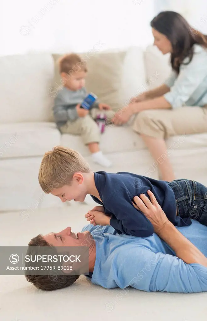 Parents with kids (12-17 months, 6-7) playing at home
