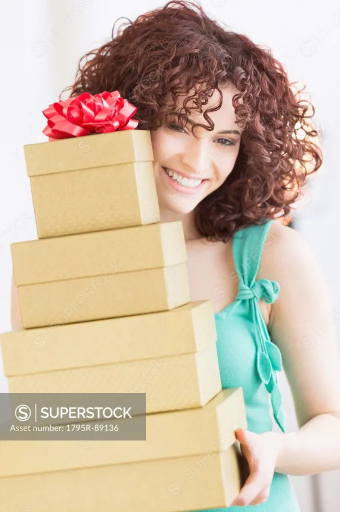 Woman holding stack of gifts