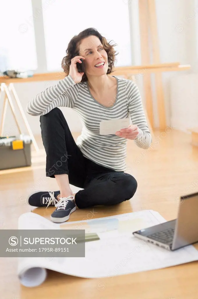 Woman talking on cell phone and using laptop