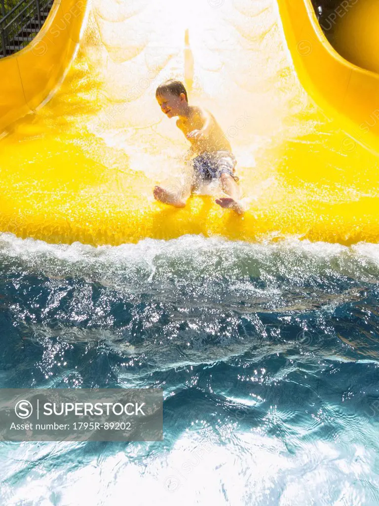 Boy (6-7) having fun on water slide