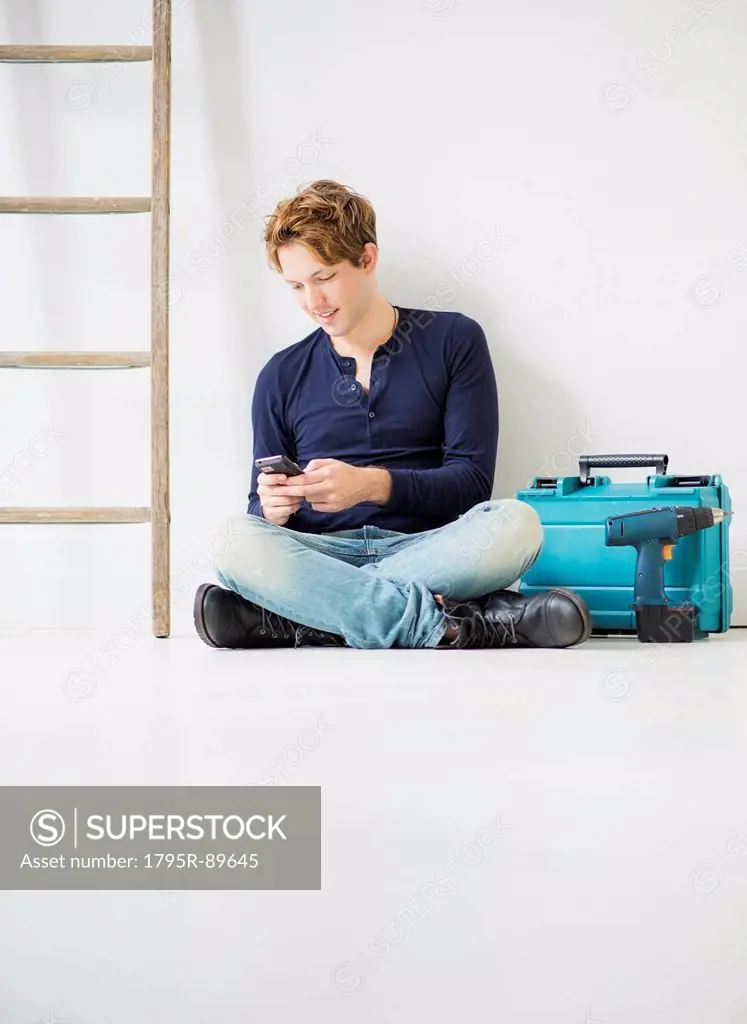 Man with toolbox using phone