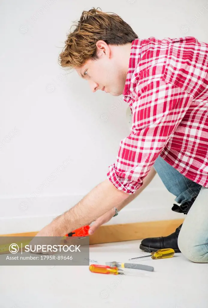 Man measuring baseboard