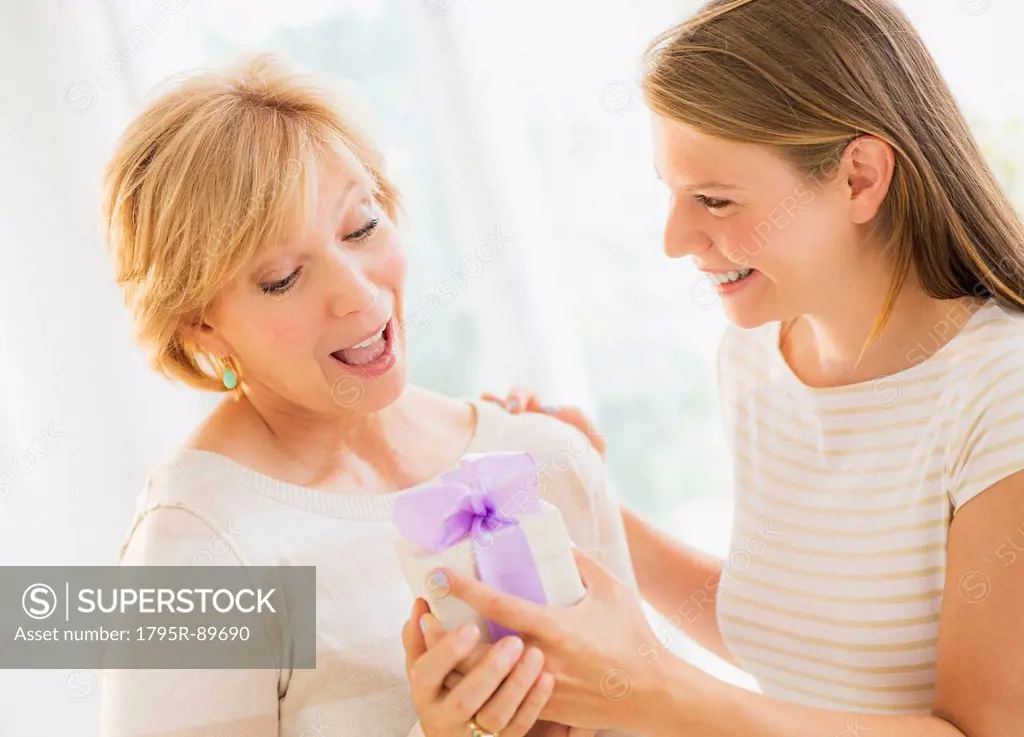 Adult daughter giving present to mother