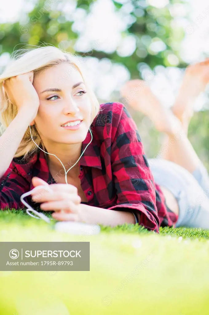 Portrait of teenage girl (16-17) lying on grass