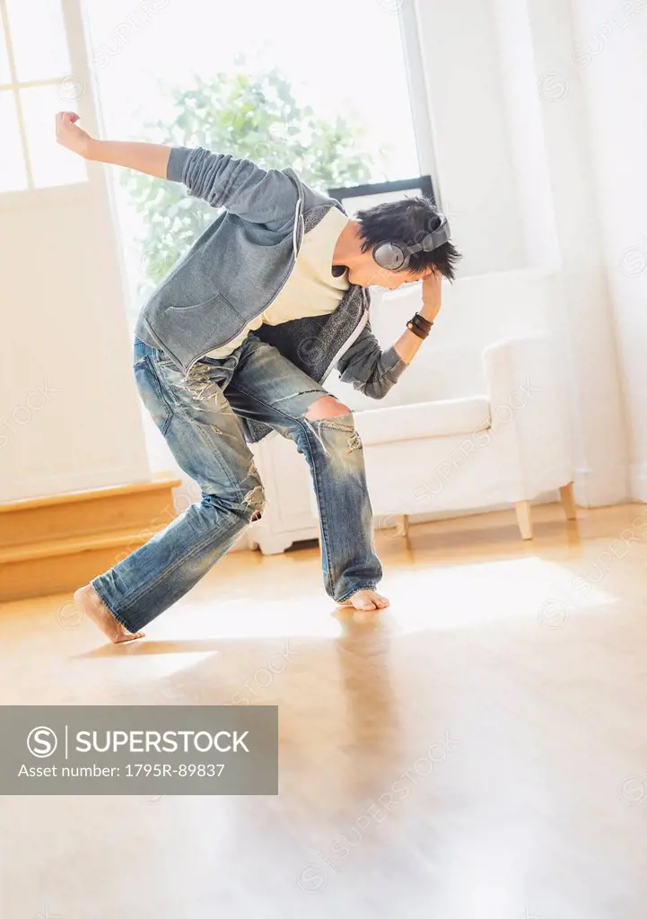 Teenage boy (16-17) dancing in living room