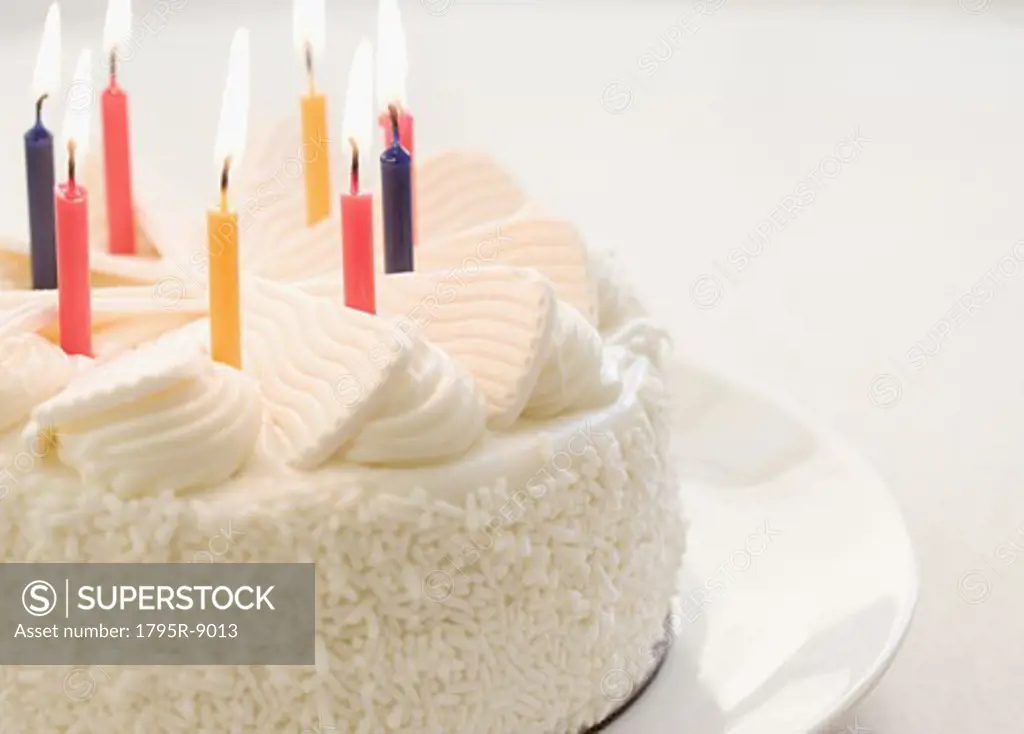White cake with lit candles
