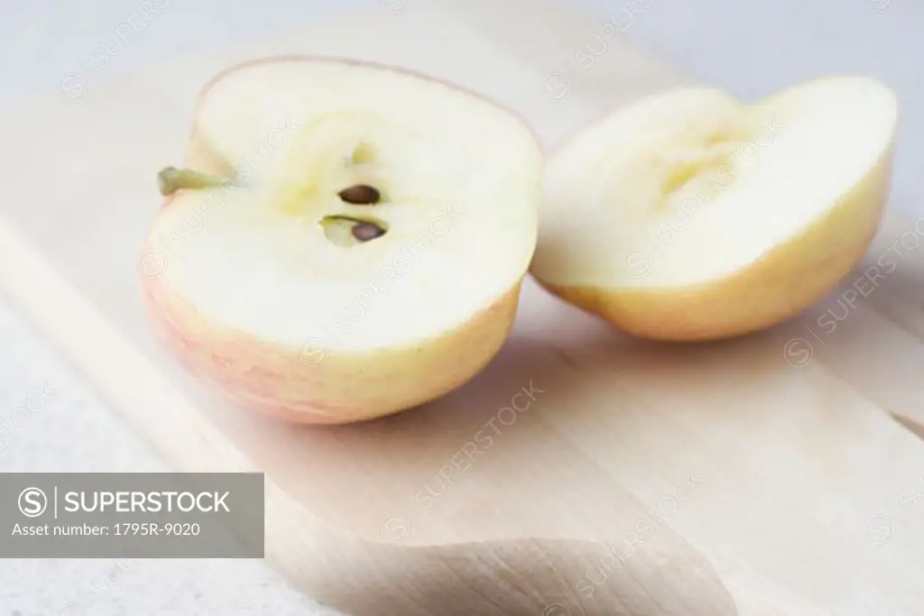 Halved apple on cutting board