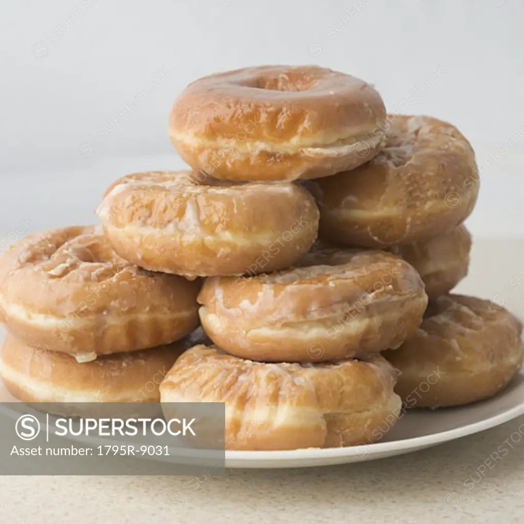 Pile of glazed donuts on plate
