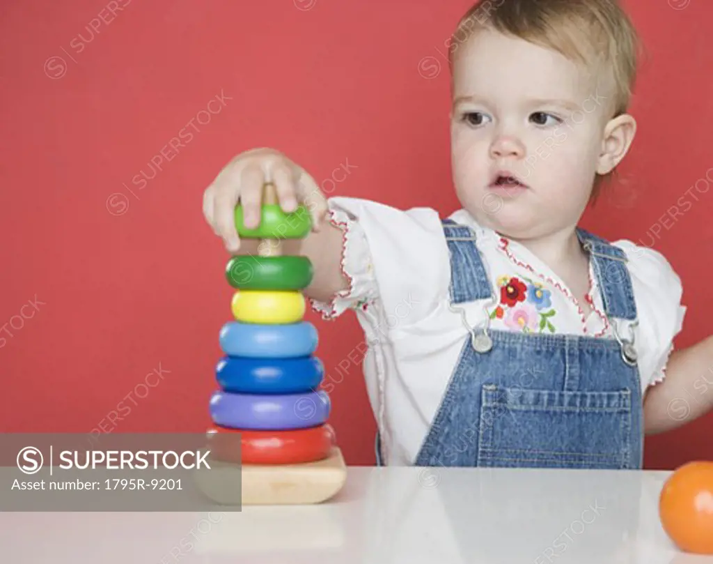 Female toddler playing with rings