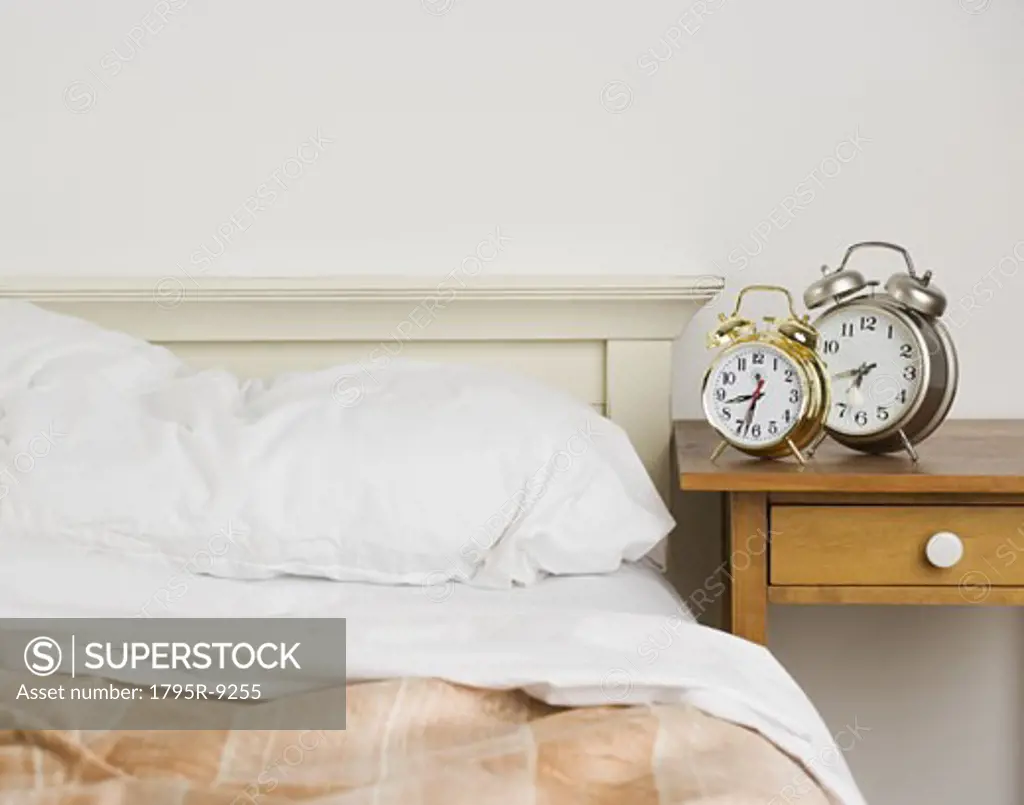 Unmade bed with alarm clocks