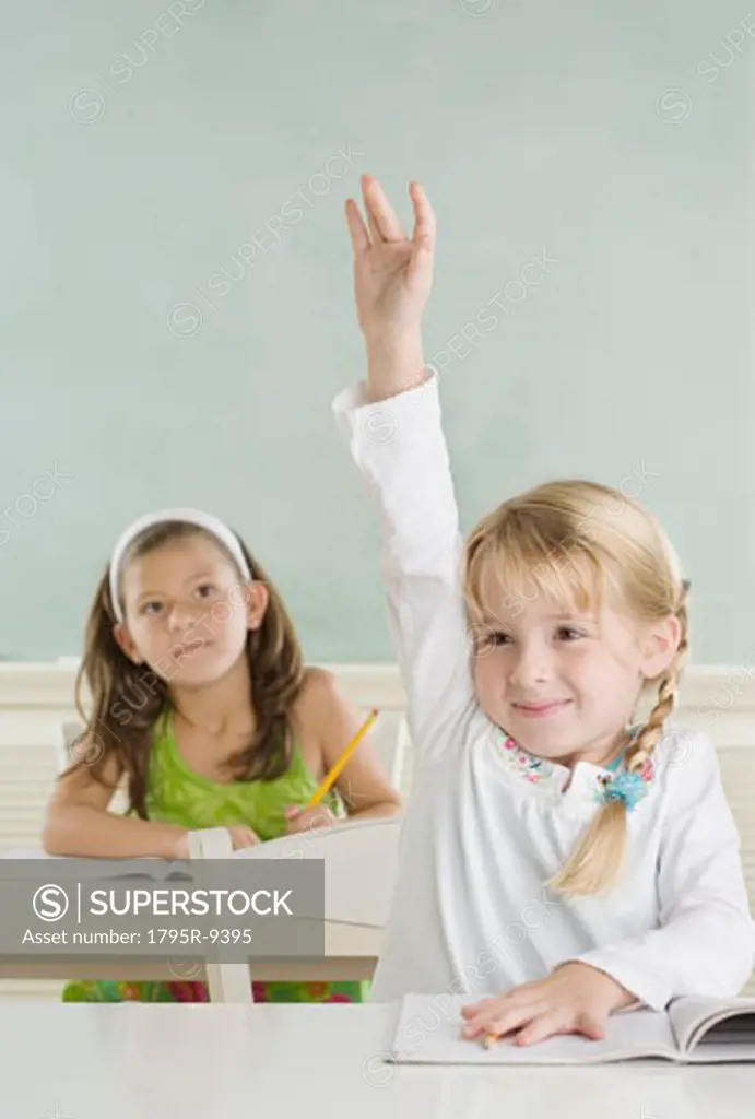 Young girl raising hand in class