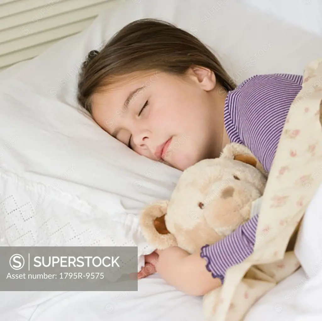 Close-up of girl sleeping with teddy bear