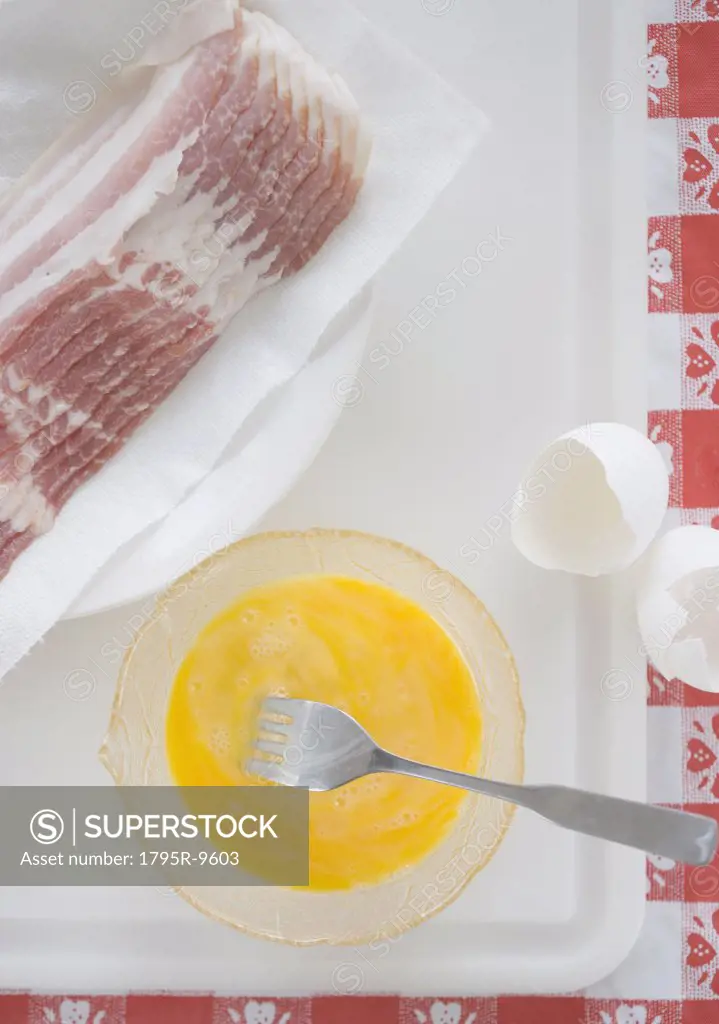 High angle view of raw bacon and eggs