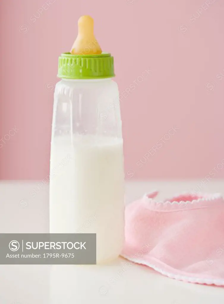 Close-up of baby bottle and bib