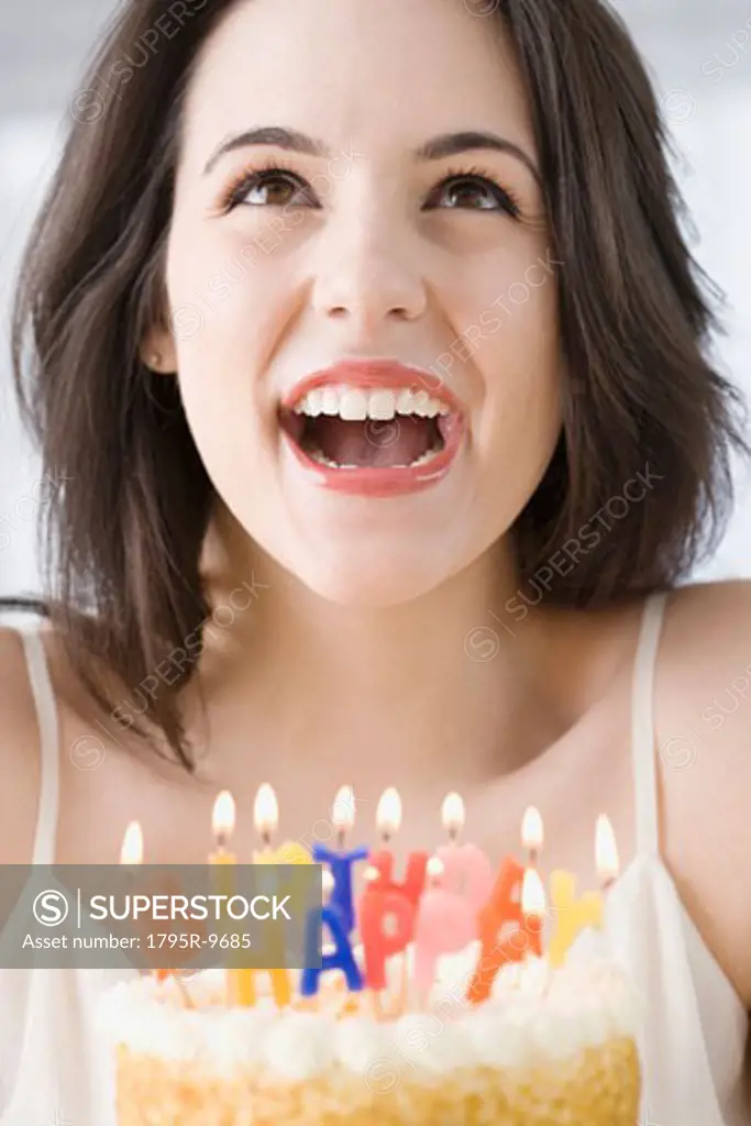 Woman laughing next to birthday cake