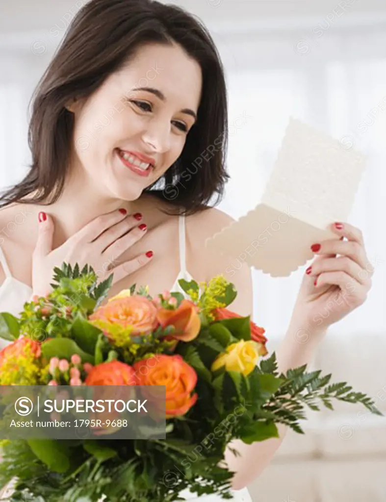 Woman reading card on flower bouquet