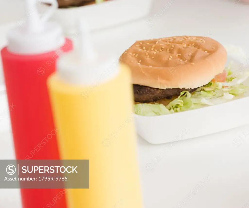 Close-up of hamburger and condiment bottles