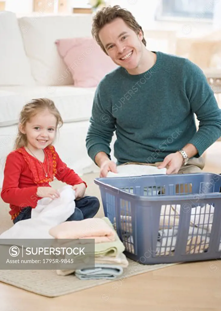 Father and daughter folding laundry