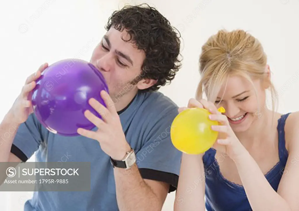 Couple blowing up balloons