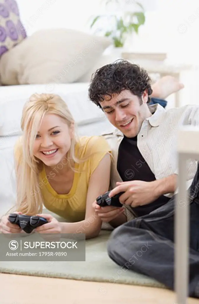 Couple playing video games on floor