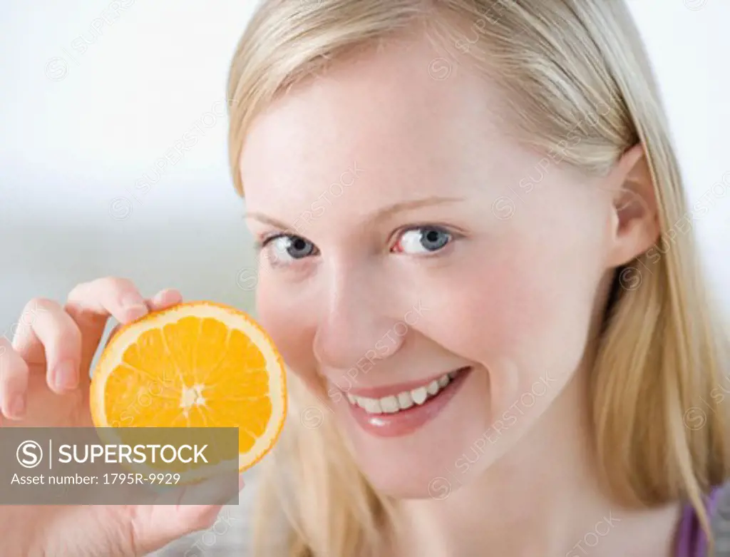 Woman holding half of orange