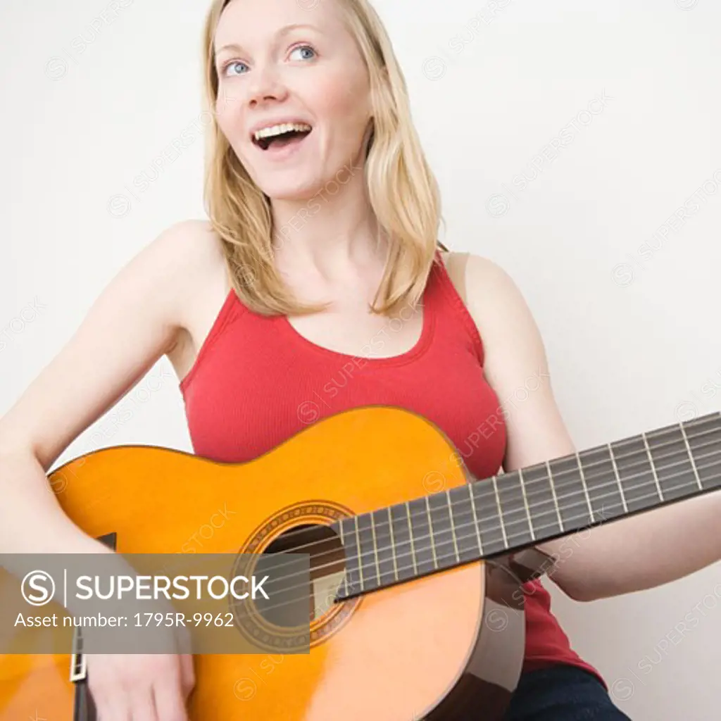 Woman paying acoustic guitar