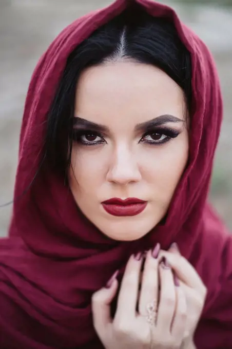 Portrait of young woman wearing red lipstick and headscarf