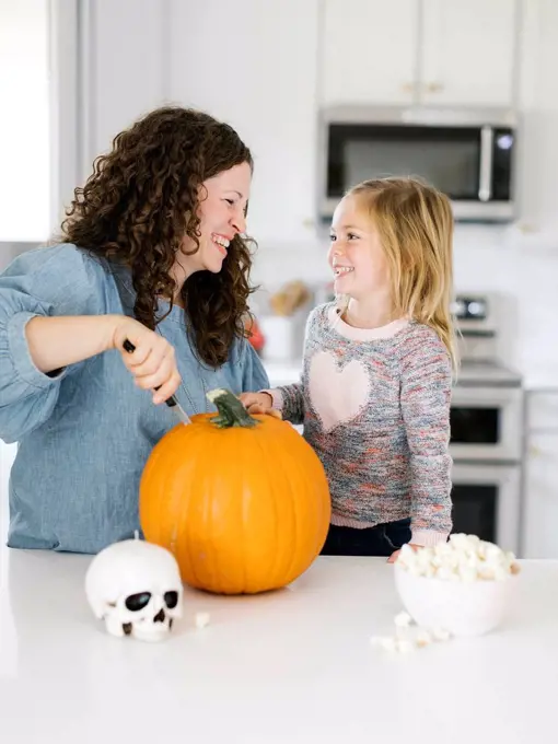 Mother and daughter carving pumpkin for Halloween