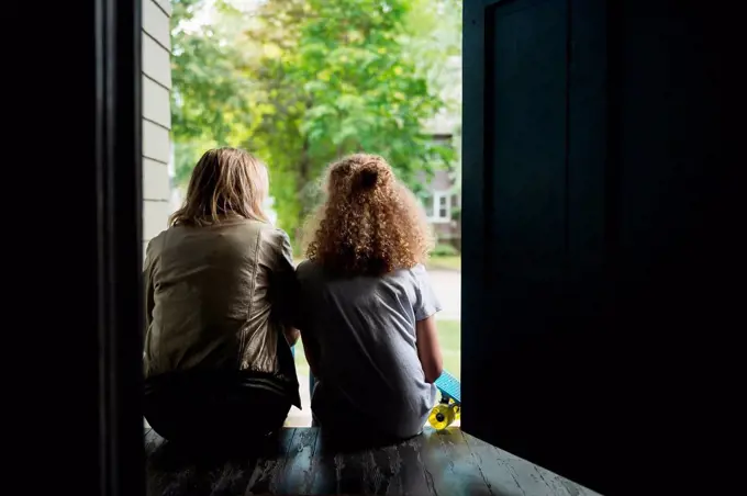 Mother and daughter sitting on porch