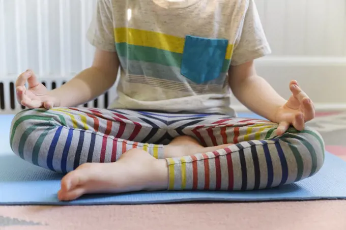 Boy (4-5) practicing yoga on mat