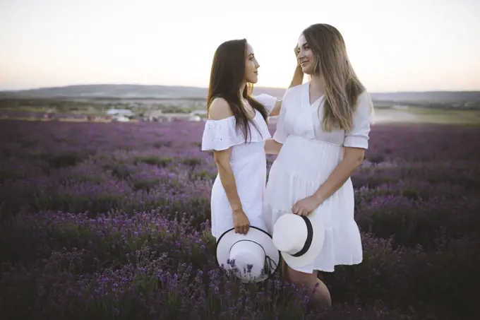 France, Young couple in white dresses standing in lavender field
