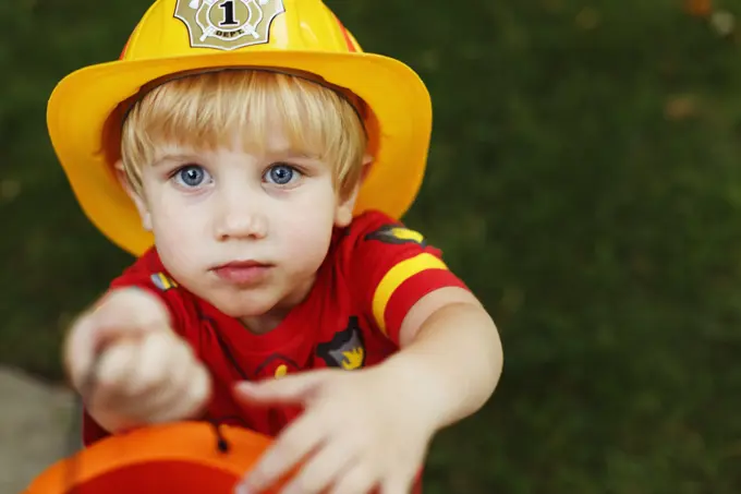 Boy wearing fireman's helmet