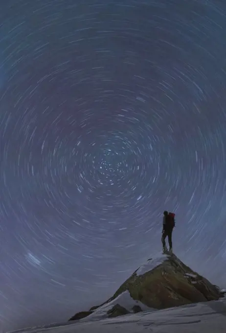 France, Haute Savoie, Chamonix, Mont Blanc, Climber standing on top of Mont Blanc and watching star trails