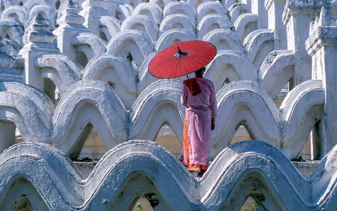 Myanmar, Mingun, Mandalay Division, Buddhist nun standing on white arches of Hsinbyume Pagoda